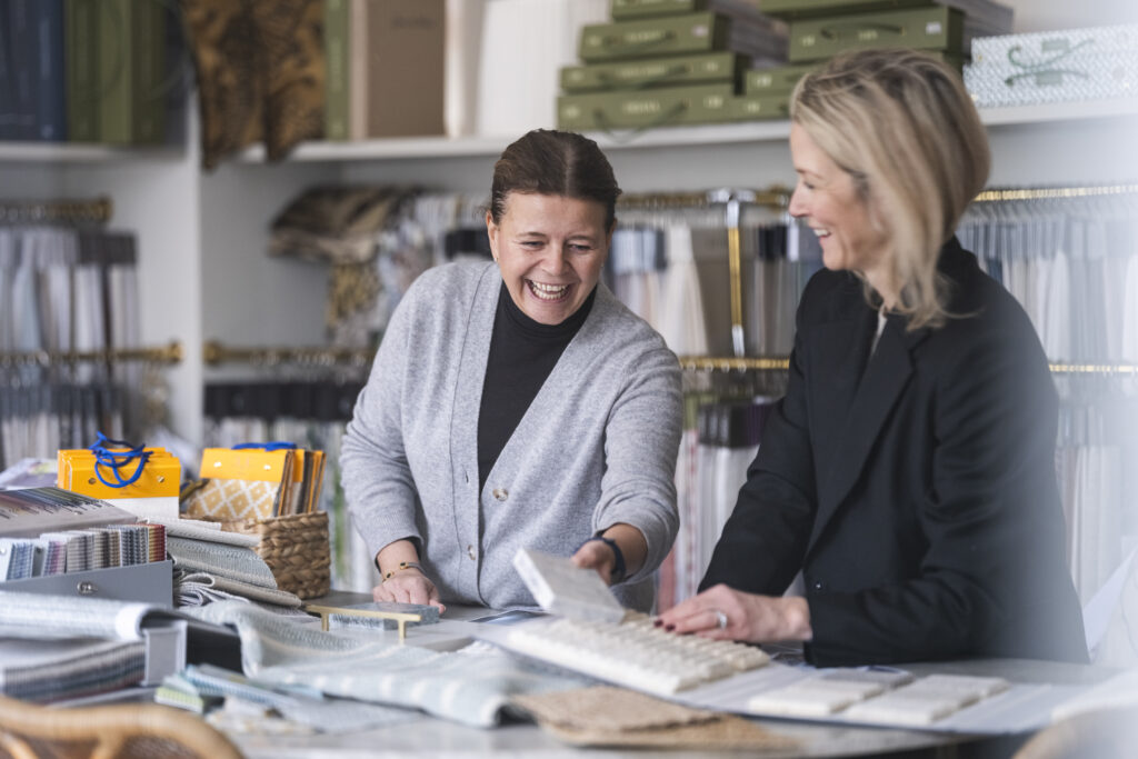 Inredare i showroom som diskuterar textilier och inredningskoncept – personligt bemötande hos Caspar & Co, Lidingö